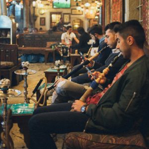 Vintage Middle Eastern teahouse with communal hookah smoking showing 19th-20th century culture